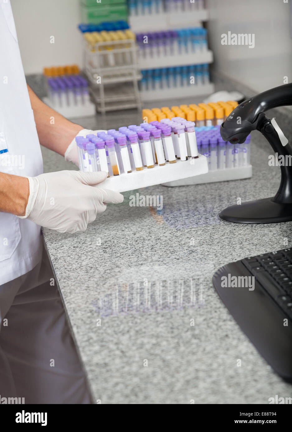 Il tecnico di contenimento tubo di prova titolare in laboratorio Foto Stock