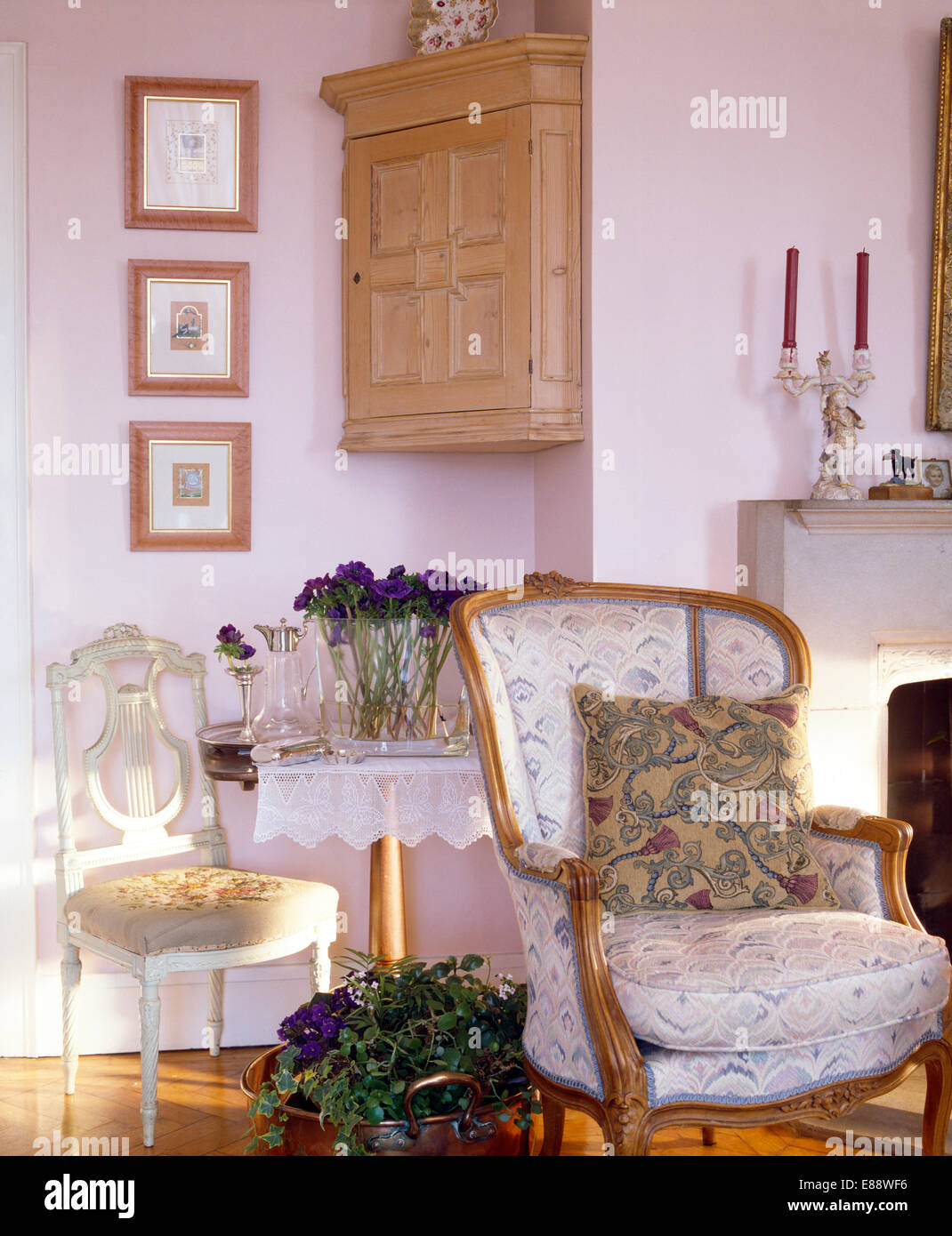 Lo stile francese di poltrona e piccola sedia antica sotto il pino angoliera  in rosa pallido soggiorno Foto stock - Alamy