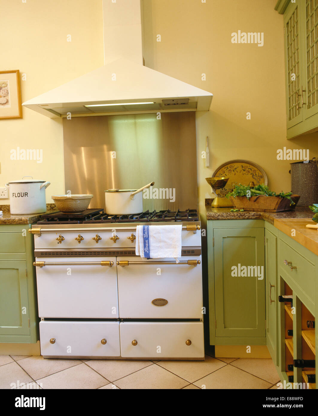Gamma in bianco forno in cucina con verde pastello montate le unità di legno Foto Stock