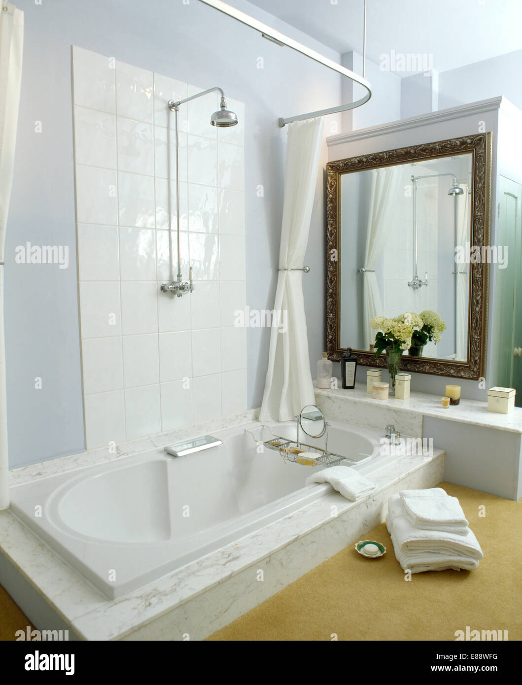 Pila di asciugamani bianchi accanto al bagno con doccia cromo in bianco e  moderno bagno con specchio grande Foto stock - Alamy