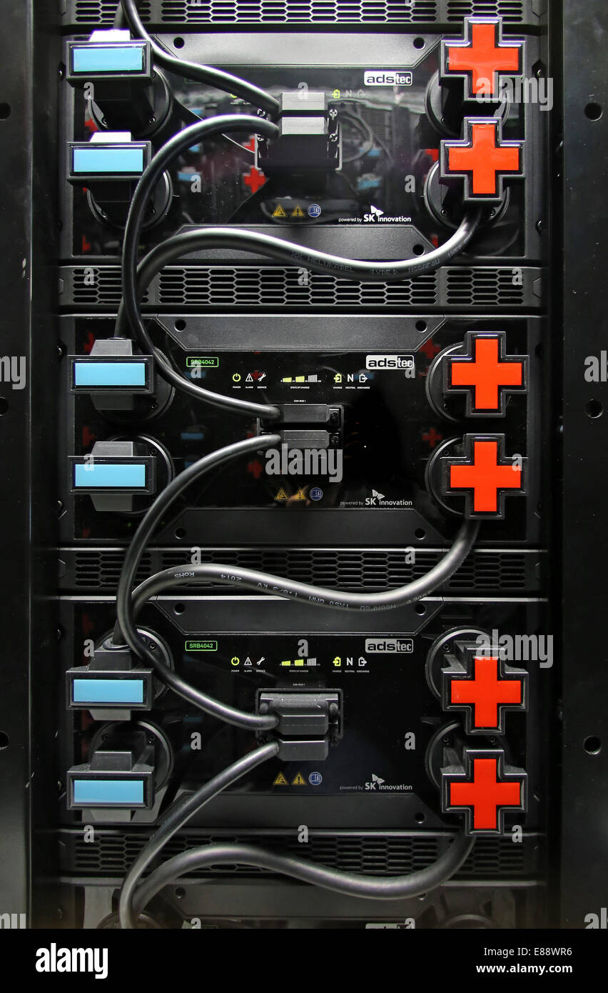 Plus e segni meno indicano i poli sulla nuova energia impianto di stoccaggio presso l'Istituto Fraunhofer per la fabbrica di funzionamento e Automazation (IFF) a Magdeburgo (Germania), 2 ottobre, 2014. Durante una full-test di scala nello stesso giorno tutta la Fraunhofer research center è stata alimentata con energia fornita dalla batteria. L a base di litio per il sistema di archiviazione dispone di una capacità di 0,5 megawatt per ora e una uscita di un megawatt. La batteria di accumulatori è alloggiata in una 26-tonnellata contenitore trasportabile. Questo tipo di apparecchiatura dovrebbe stabalize successive variazioni nelle reti di energia.Foto: Jan Woitas/dpa Foto Stock
