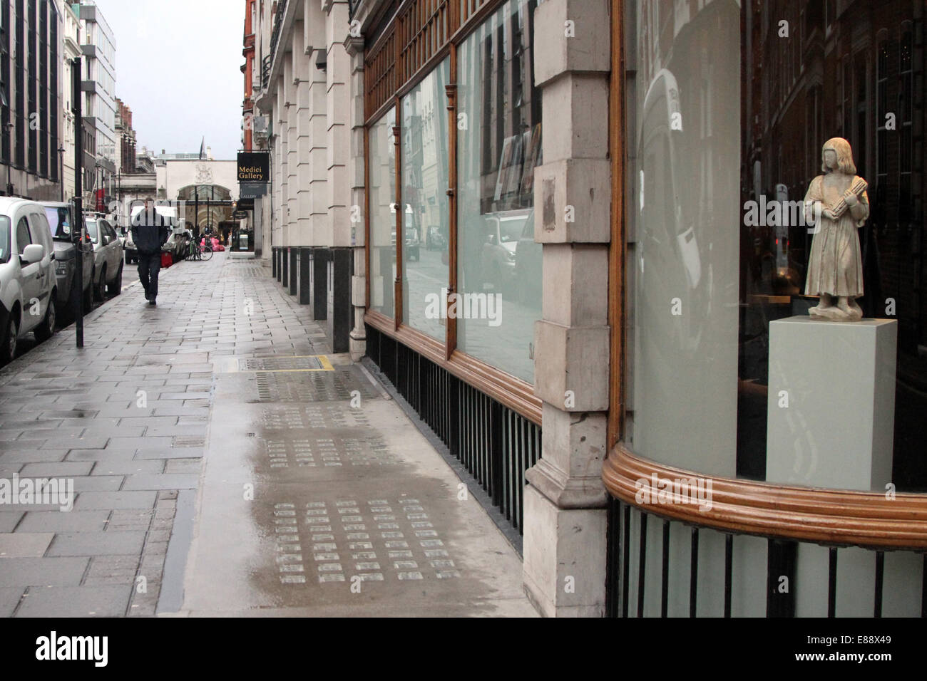Un pedone passato passeggiate nelle gallerie d'arte lungo la Cork Street su un panno di giorno a Londra, Regno Unito Foto Stock