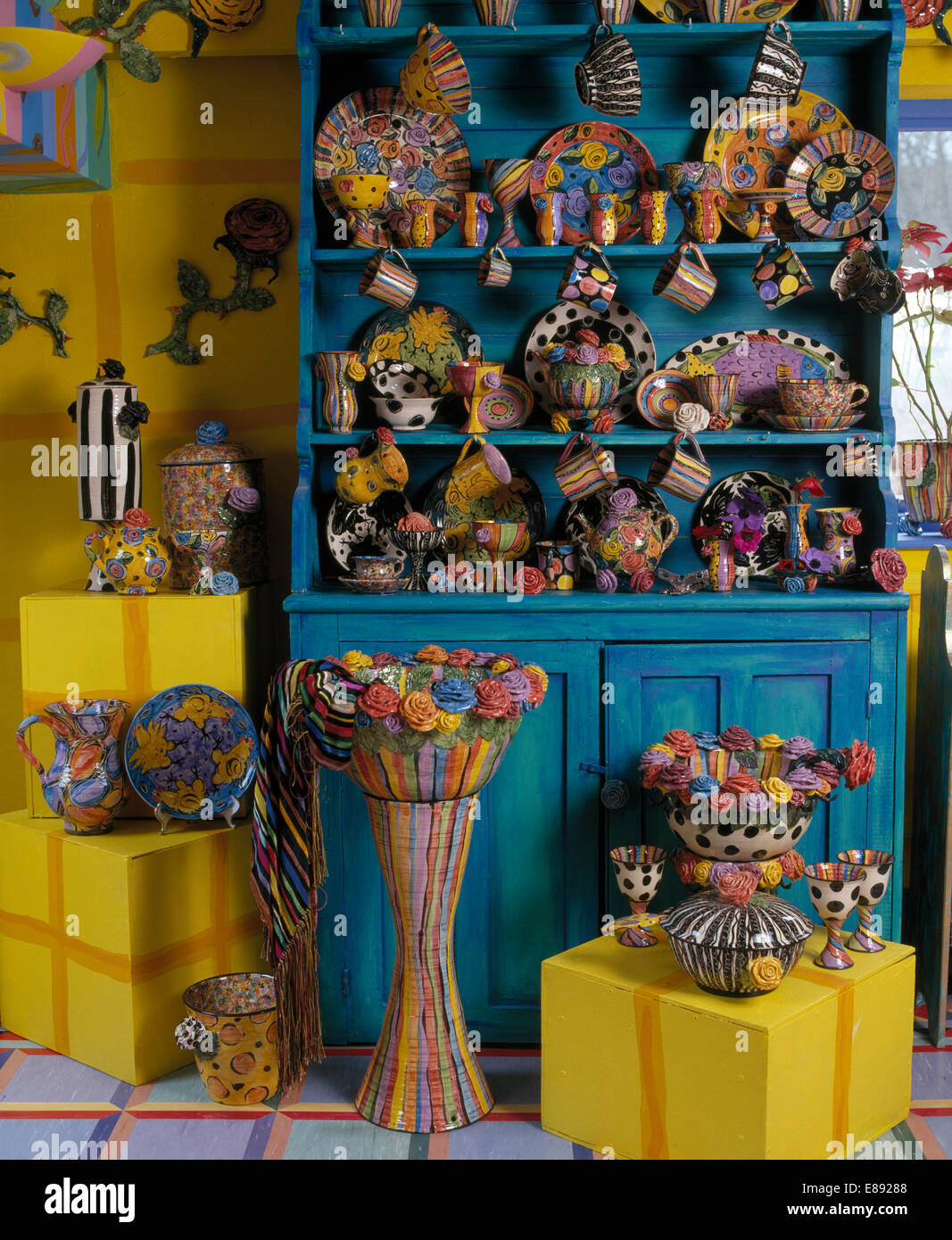 Collezione di coloratissimi Mary Rose Giovani in ceramica sul comò turchese e su sgabelli di colore giallo Foto Stock