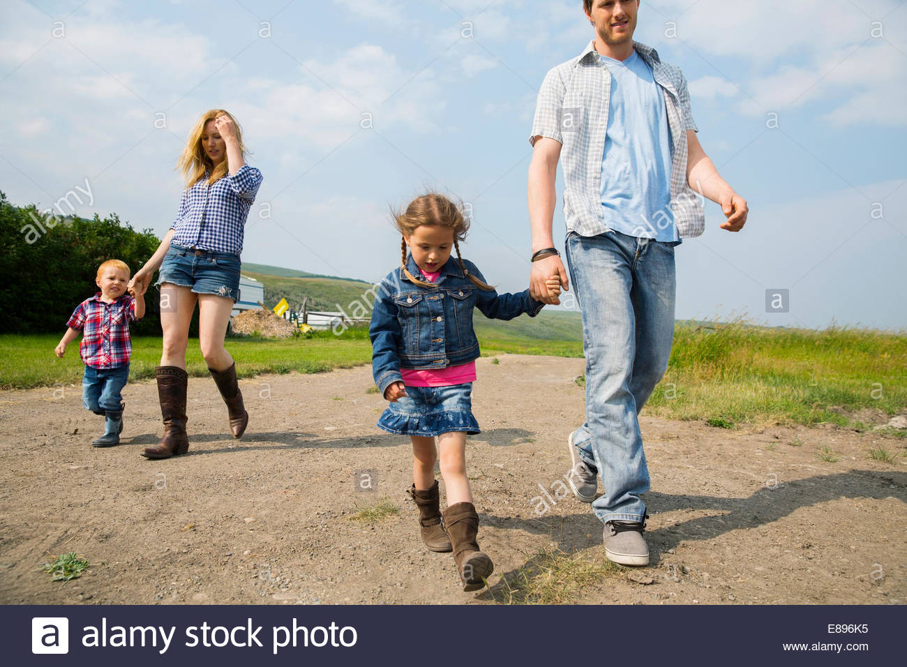 Famiglia passeggiate su rurale strada sterrata Foto Stock