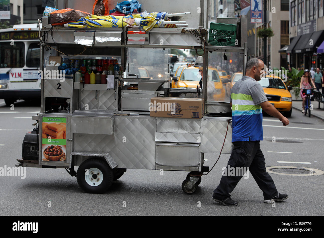 La città di New York, Stati Uniti d'America, l'uomo si ritira la sua concessione mobile stand dietro di lui Foto Stock