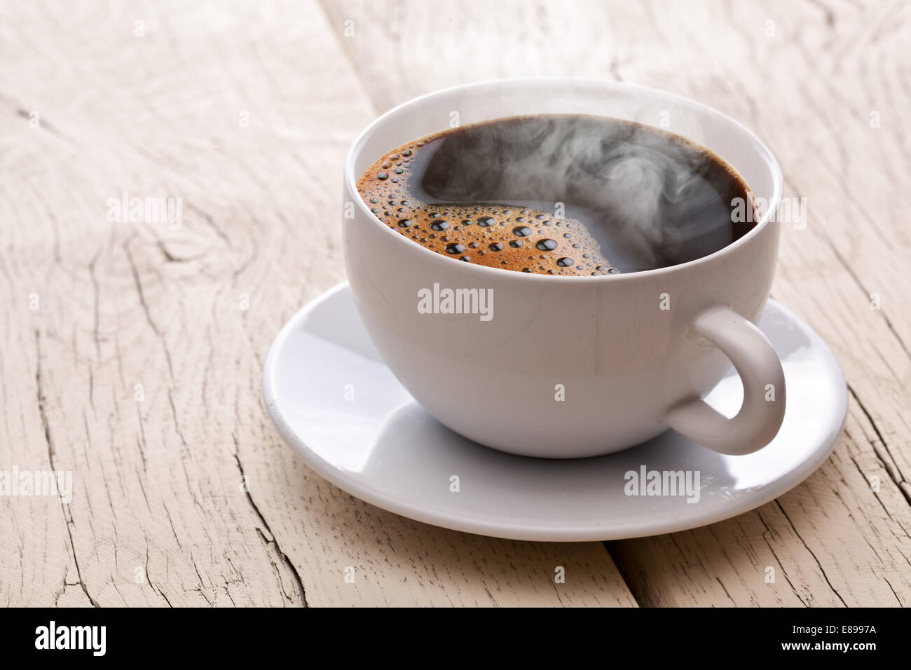 Tazza di caffè caldo su un vecchio tavolo di legno. Foto Stock