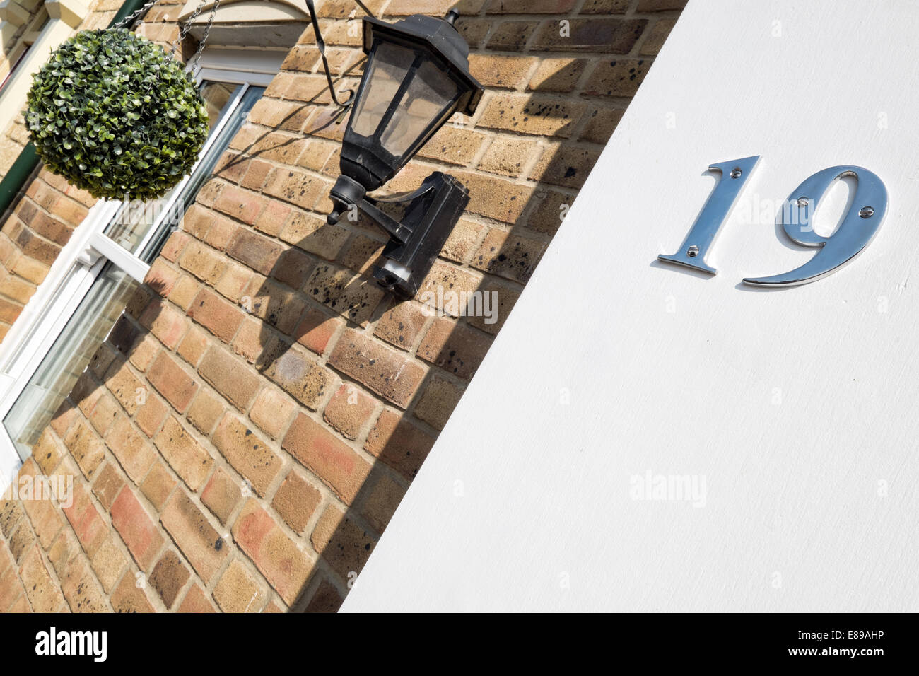 Un numero di cromo 19 su uno stucco bianco parete, utilizzata per identificare la casa di indirizzo Foto Stock