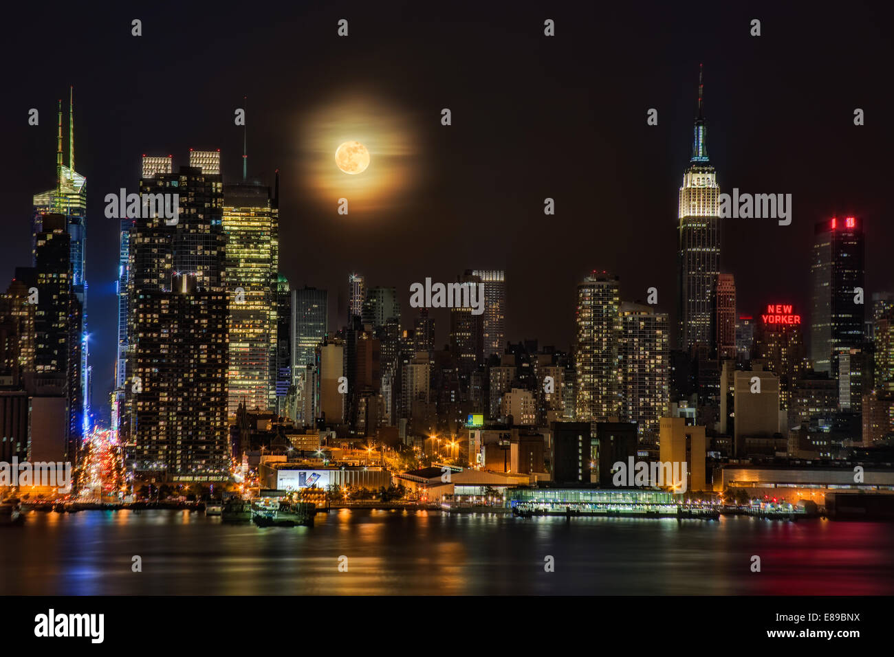 La Super Luna sorge oltre l'orizzonte di New York City. Foto Stock