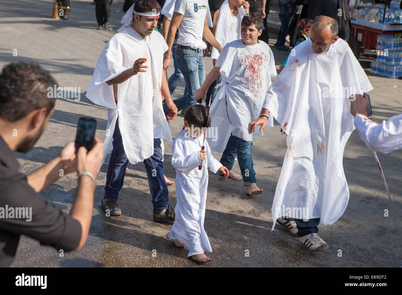 Tre generazioni di mussulmano sciita uomini con auto-inflitte ferite di testa, commemorare il giorno di Ashura in Nabatieh, Libano. Foto Stock