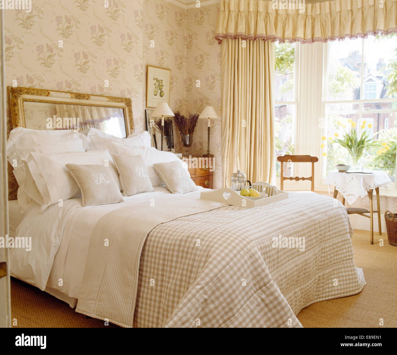 Specchio usato come testata sul letto con croccante biancheria bianca e  crema quilt controllato in stile country camera da letto Foto stock - Alamy