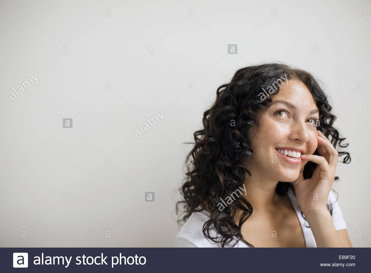 Curioso donna con ricci capelli neri Foto Stock