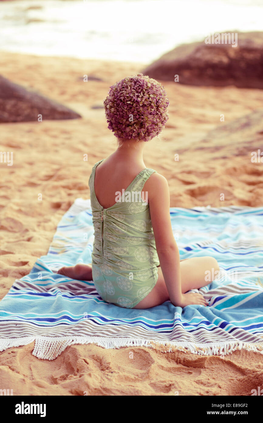 La ragazza di swimcap seduto sulla spiaggia coperta Foto Stock