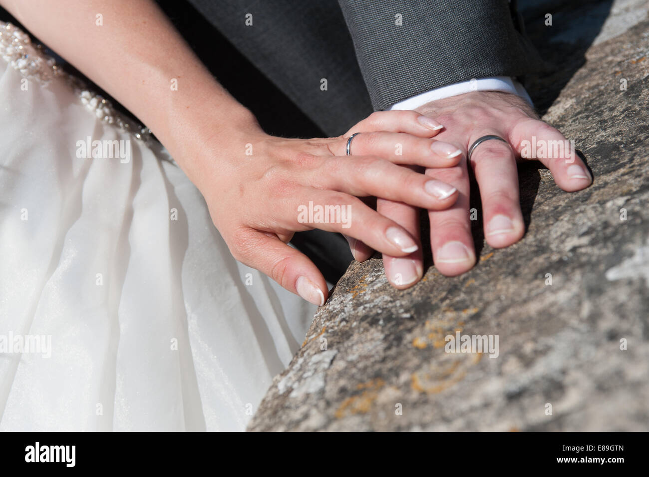 Una sposa sposa amorevolmente toccare la mano del suo nuovo marito Foto Stock