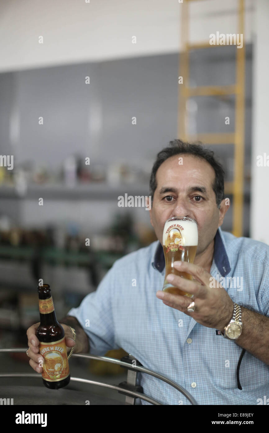 Ramallah, birreria palestinese fondato nel 1994. 2 Ottobre, 2014. Un lavoratore palestinese gusti di nuova birra fermentata all'interno di Taybeh Birra Birreria, la sola birreria palestinese fondato nel 1994, in Cisgiordania villaggio di Taybeh il 2 ottobre, 2014. © Fadi Arouri/Xinhua/Alamy Live News Foto Stock