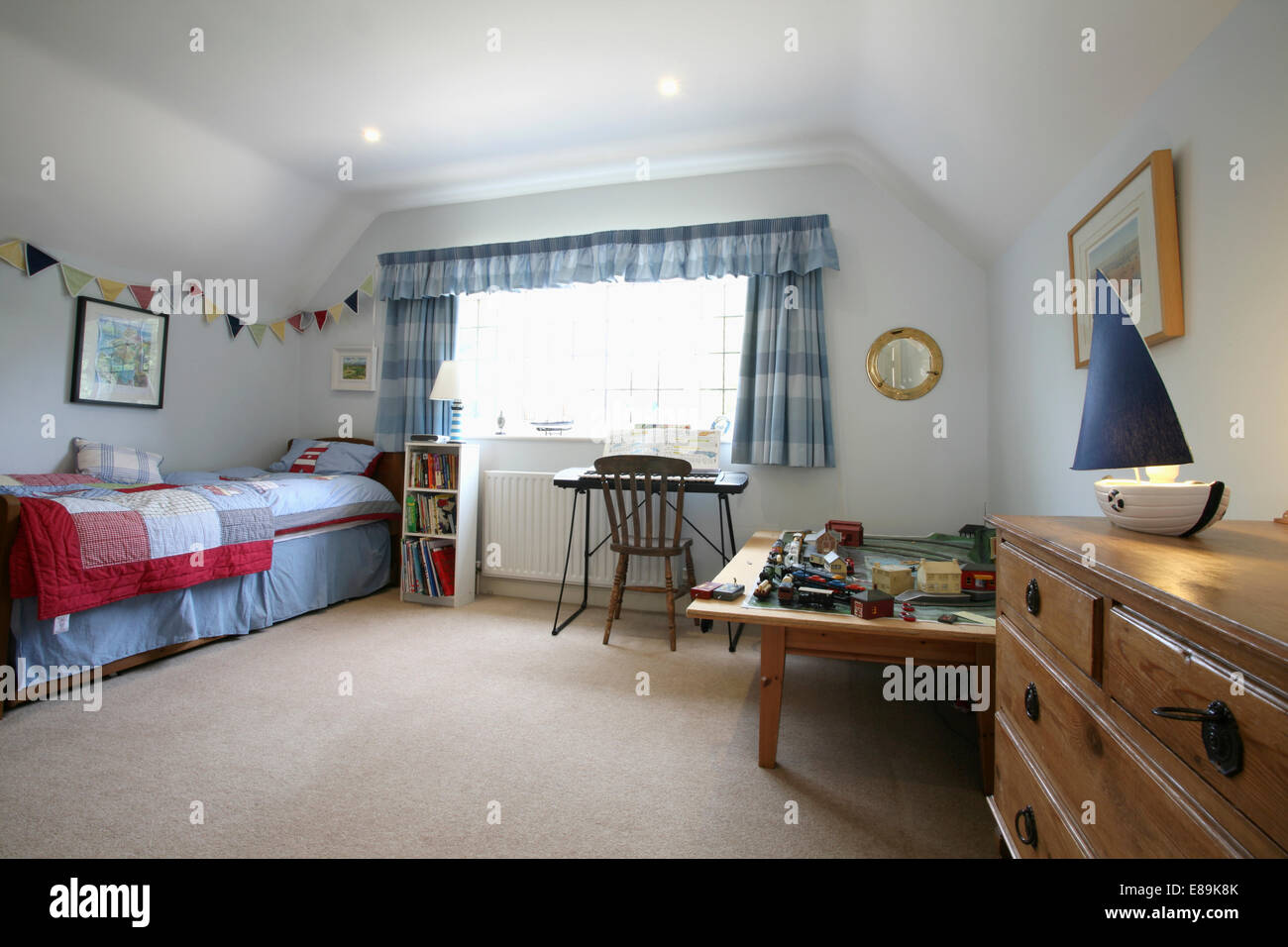 Tappeto color crema e blu e bianca controllato tende in ragazzo in camera  da letto con il treno impostato sul tavolo basso Foto stock - Alamy