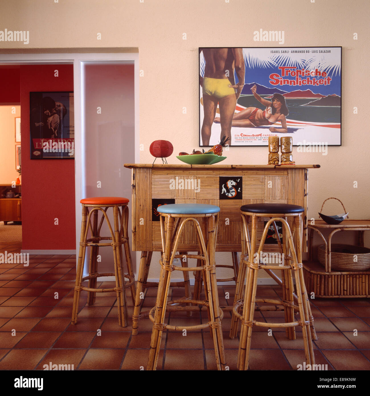 Sgabelli di bambù e cocktail armadio in cinquanta-sala da pranzo in stile con grandi poster sulla parete Foto Stock