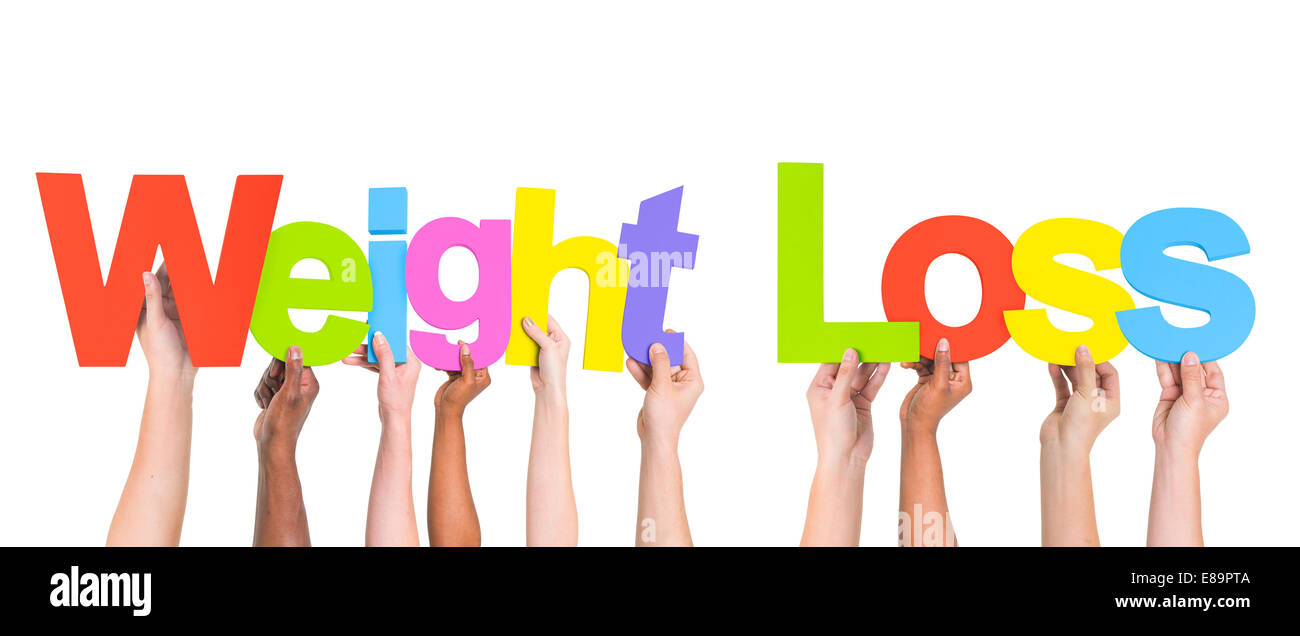Multietnica a braccia alzate tenendo testi perdita di peso Foto Stock