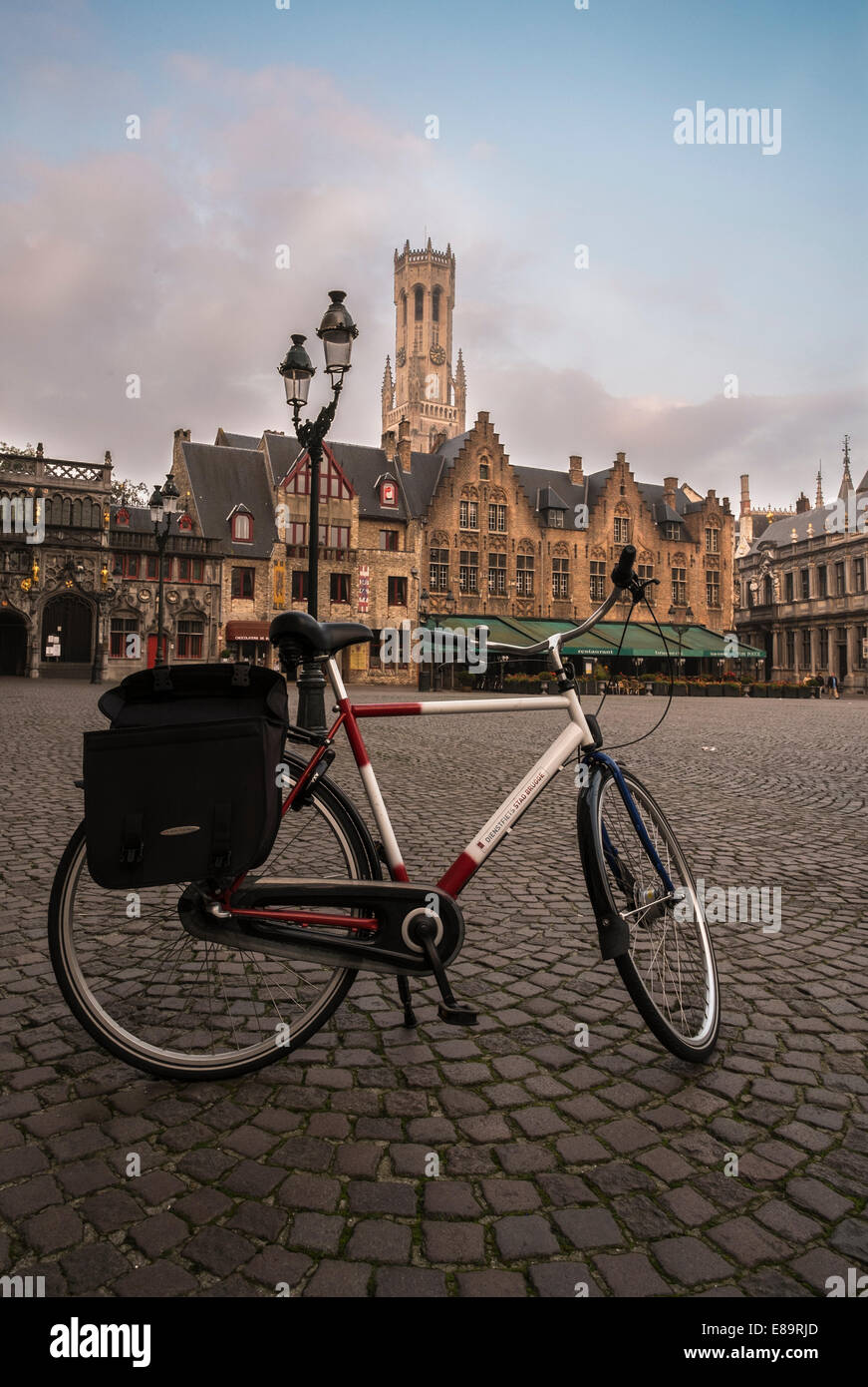 Bicicletta su Piazza Burg in Bruges con la torre campanaria in background Foto Stock