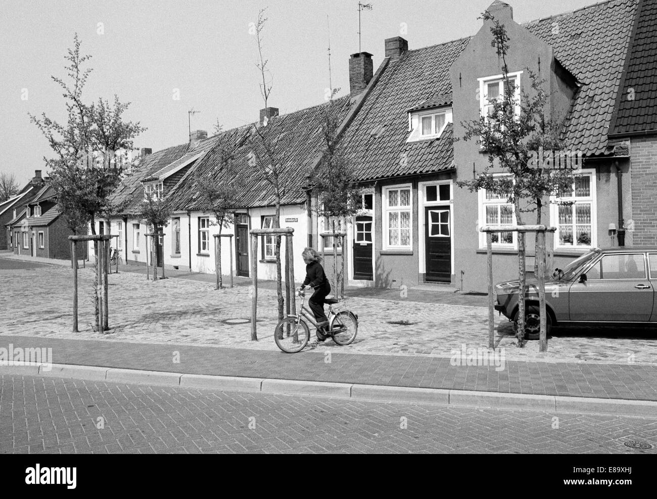 Achtziger Jahre, Maedchen mit Fahrrad, Wohnhaeuser in der Brummelburgstrasse von Leer, Ostfriesland, Bassa Sassonia Foto Stock