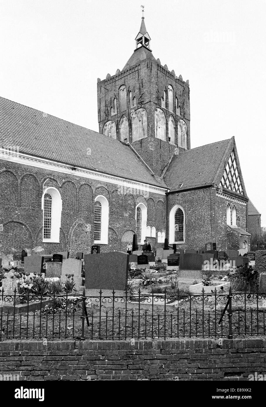 Achtziger Jahre, Evangelisch-reformierte Kirche San Stephanus im Stil der Spaetromanik mit Friedhof in Krummhoern-Pilsum, Ostfriesland, Nordsee, Niede Foto Stock