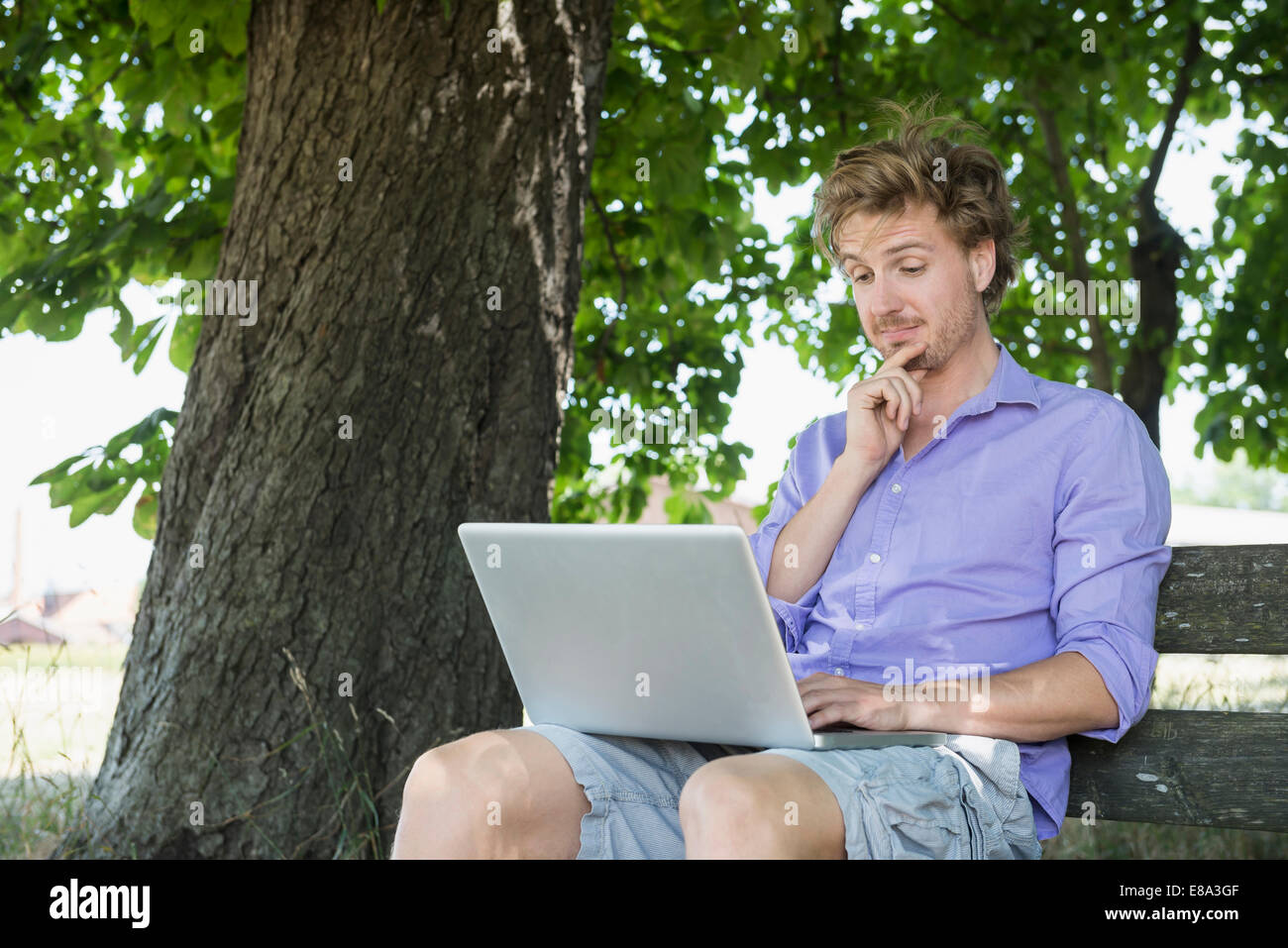 Metà uomo adulto utilizzando laptop sul banco di lavoro Foto Stock