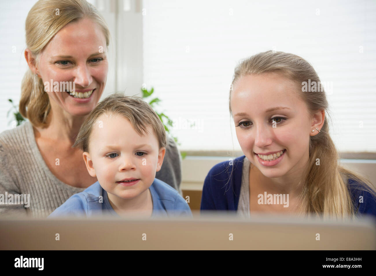 Figlia della madre e figlio divertito dai qualcosa in internet Foto Stock