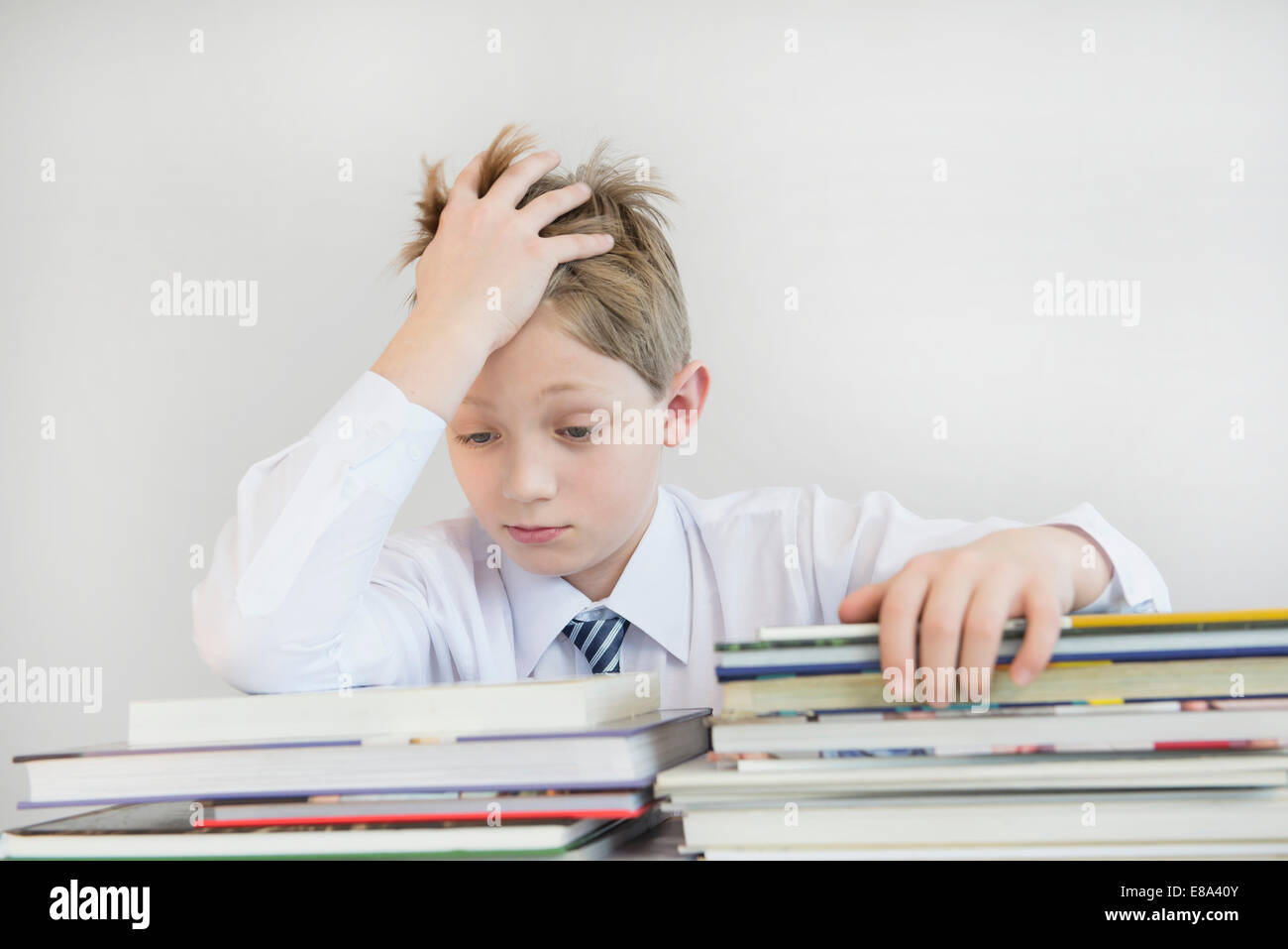 Frustrati ragazzo con pila di libri, close up Foto Stock