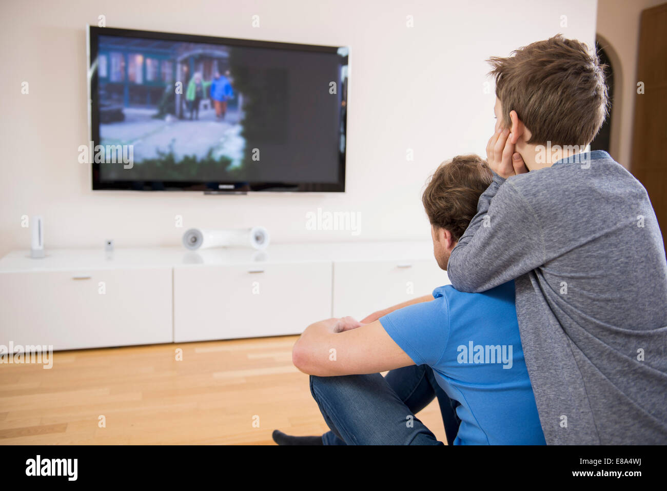Padre e figlio guardando la TV a casa Foto Stock