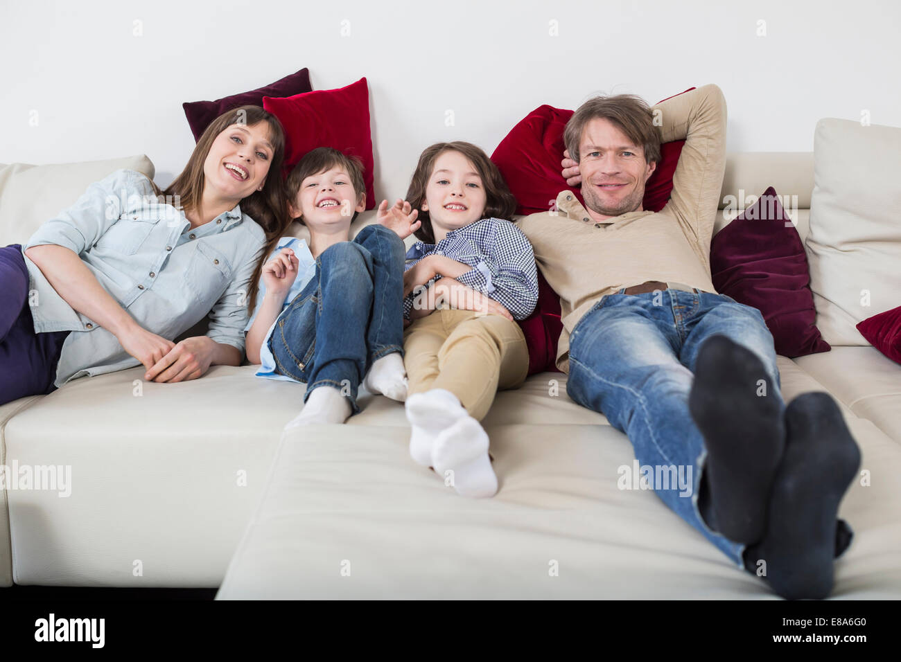 Ritratto di famiglia sdraiato sul lettino, sorridente Foto Stock Ritratto di famiglia sdraiato sul lettino, sorridente Foto Stock