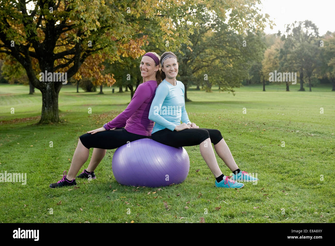 Delle donne che esercitano nel parco con sfera di fitness, Woerthsee, Baviera, Germania Foto Stock