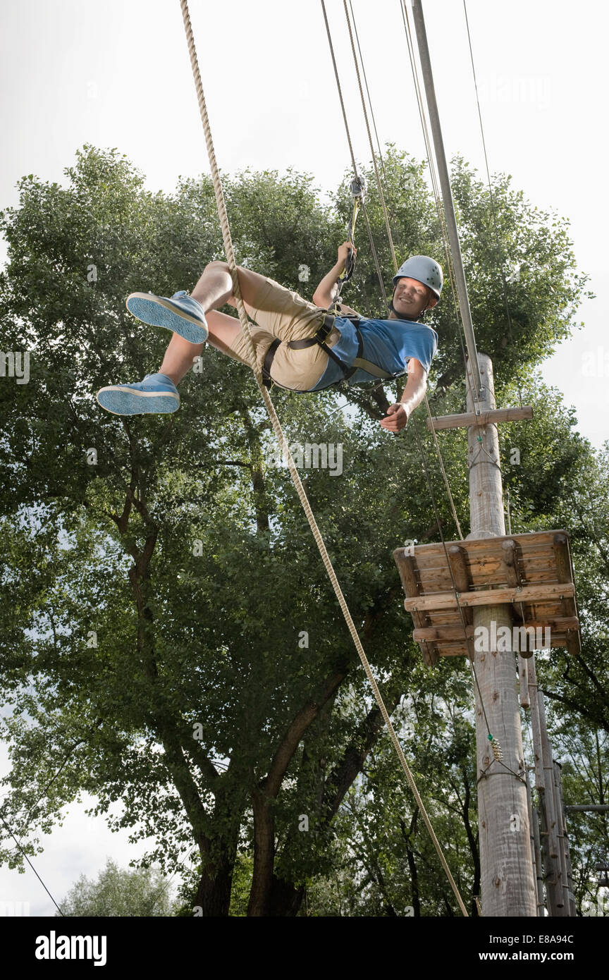 Adolescente in una rupe di arrampicata Foto Stock