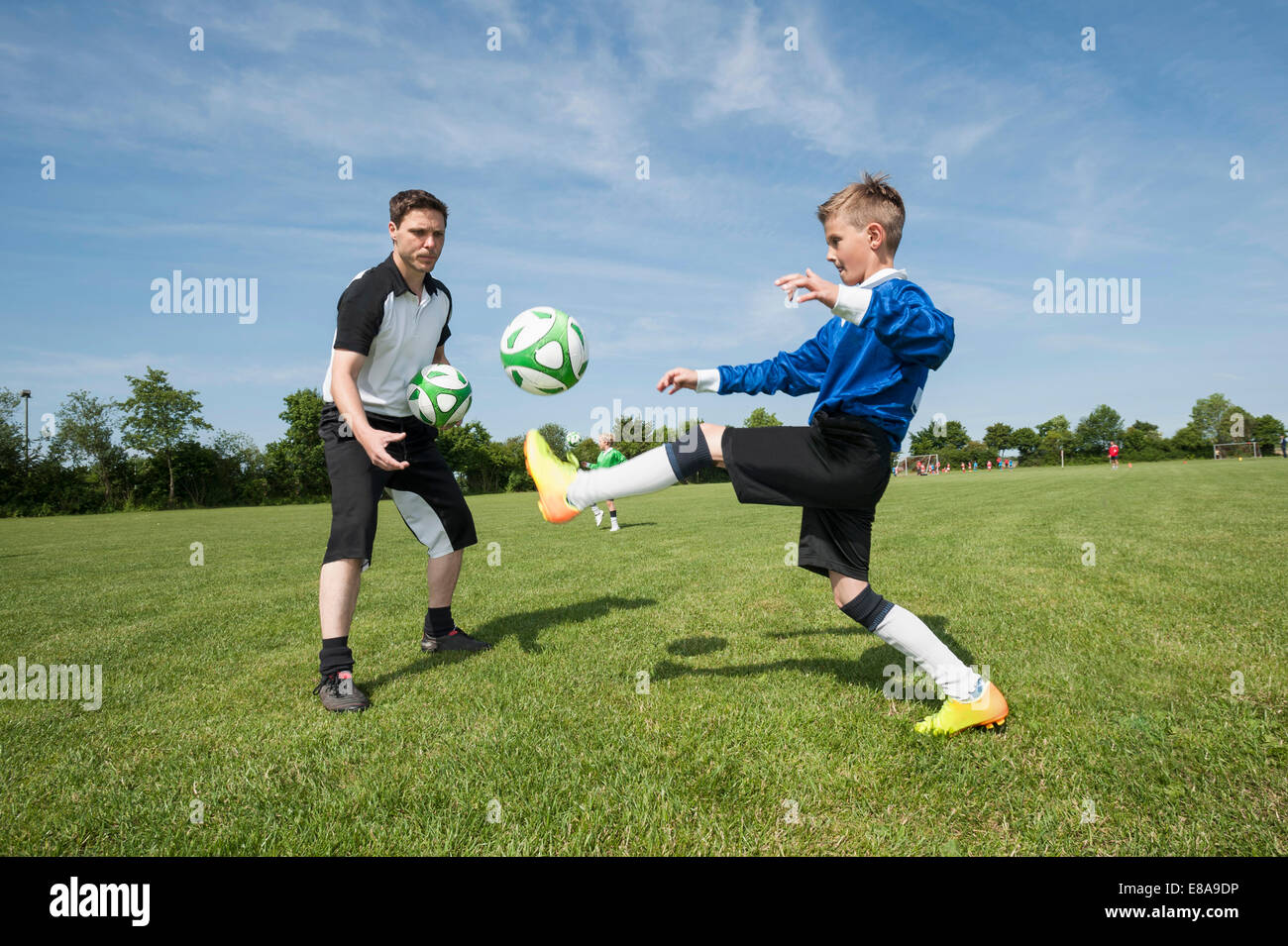 Soccer trainer insegnare ai giovani player aiutando Foto Stock