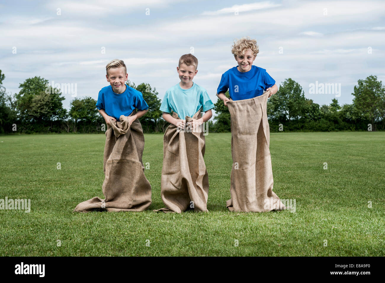 Tre giovani ragazzi preparando per sackrace Foto Stock