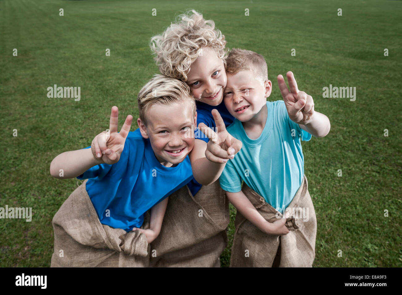 Tre giovani ragazzi bionda in posa Sackrace Foto Stock