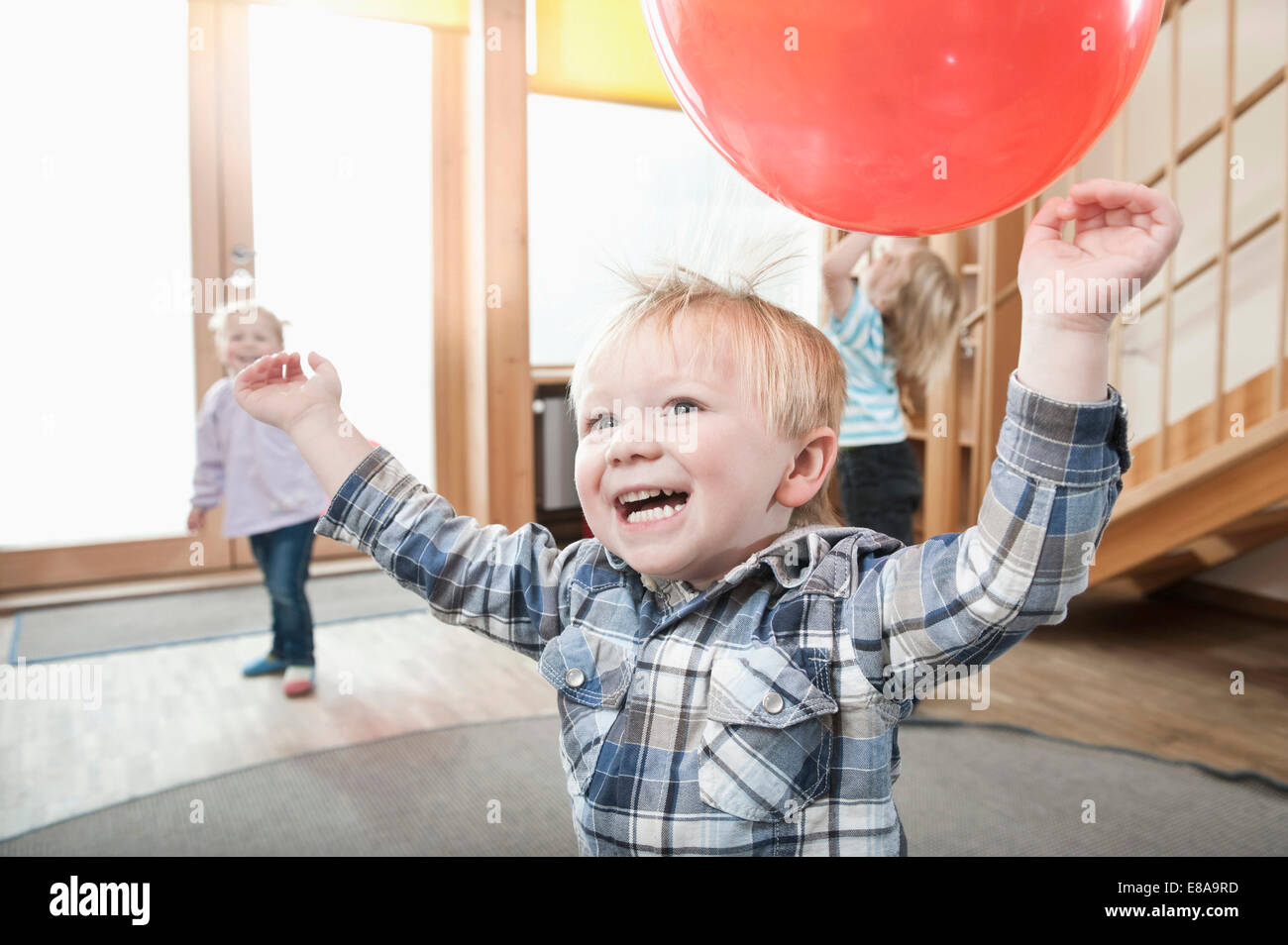Bambini che giocano con palloncini rossi in kindergarten Foto Stock