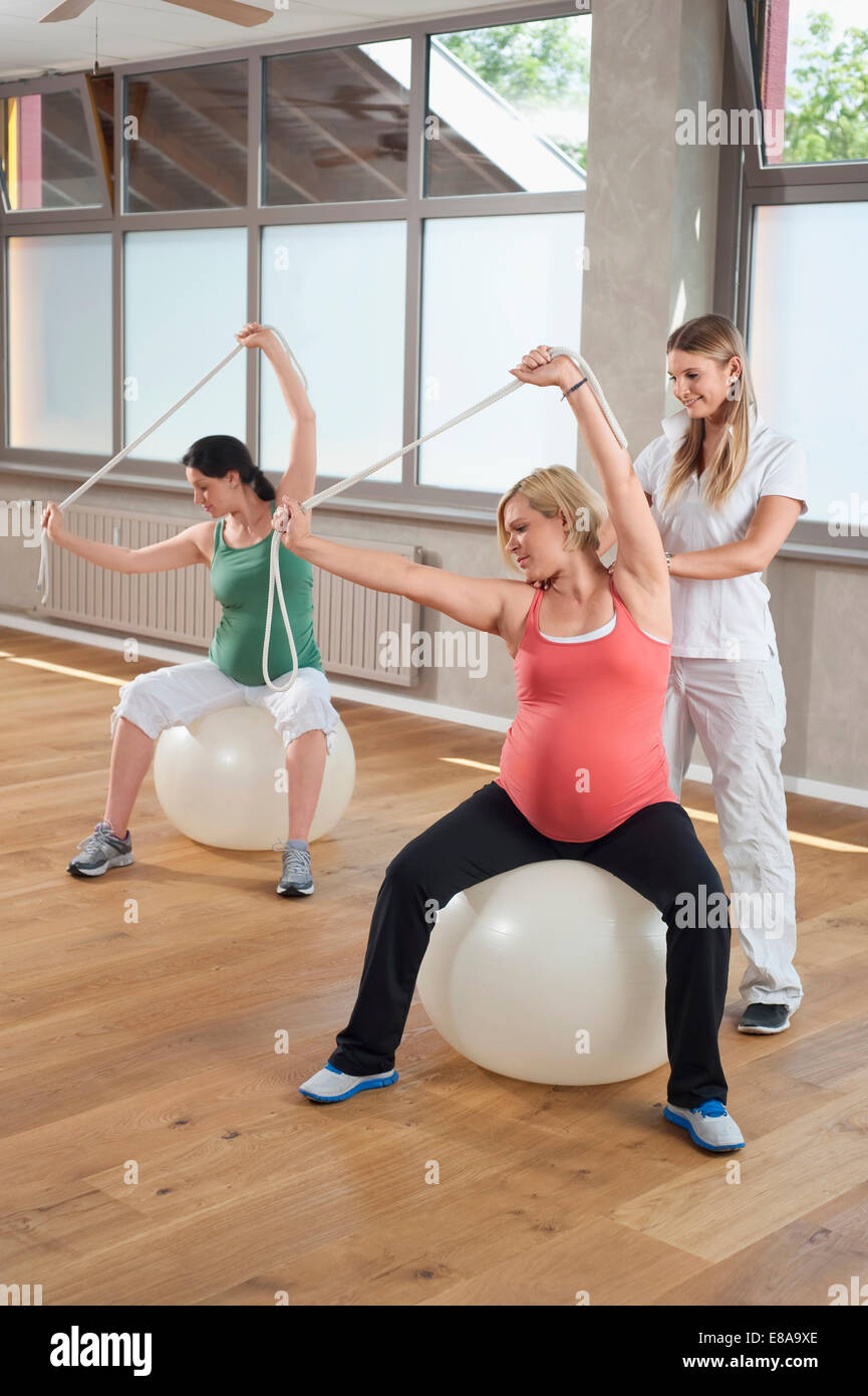 Femmina di fitness trainer donna incinta Pilates ball Foto Stock