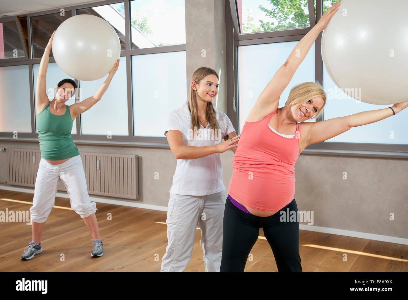 Femmina di fitness trainer donna incinta Pilates ball Foto Stock