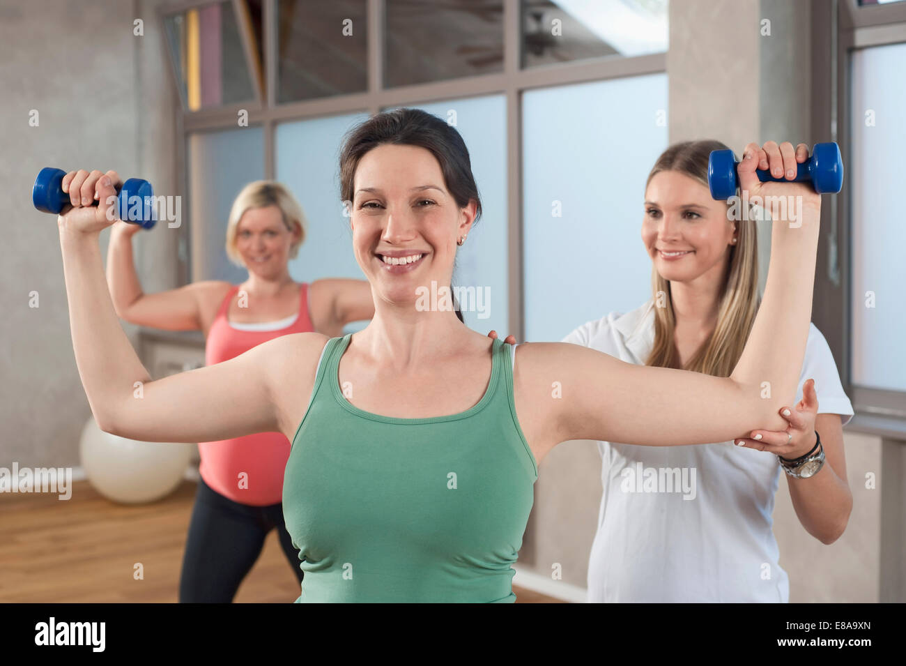 Allenatore Femmina fitness training due donna in stato di gravidanza Foto Stock