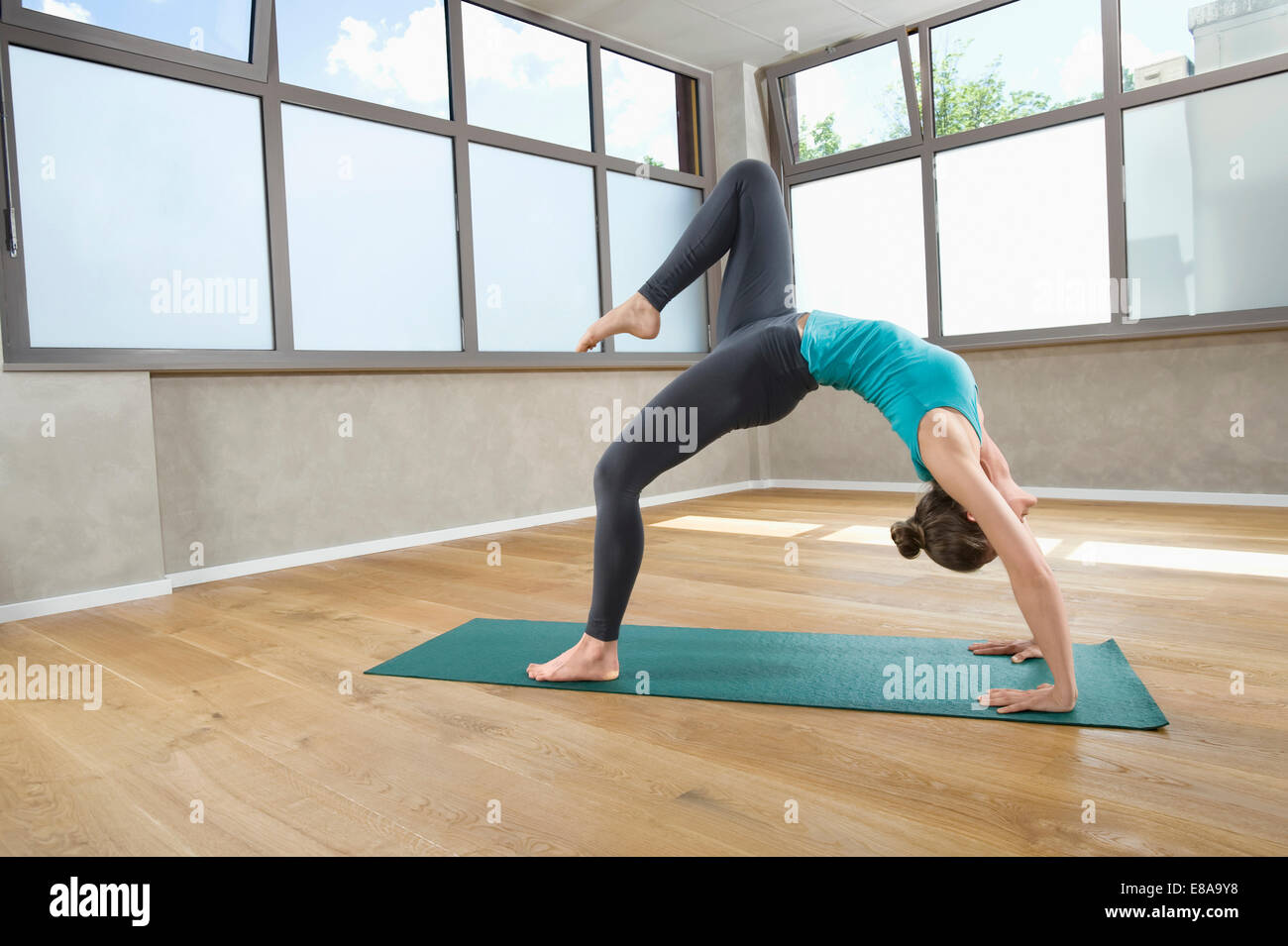 La donna da sola montare fitness studio yoga esercizio Foto Stock