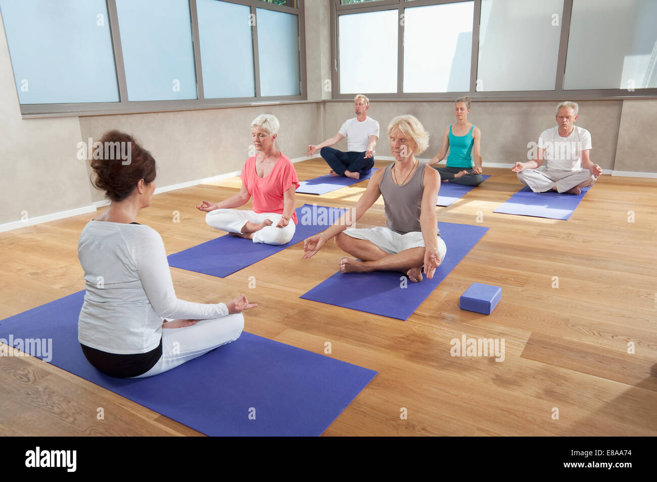 Yoga classe istruttore senior la meditazione di gruppo Foto Stock