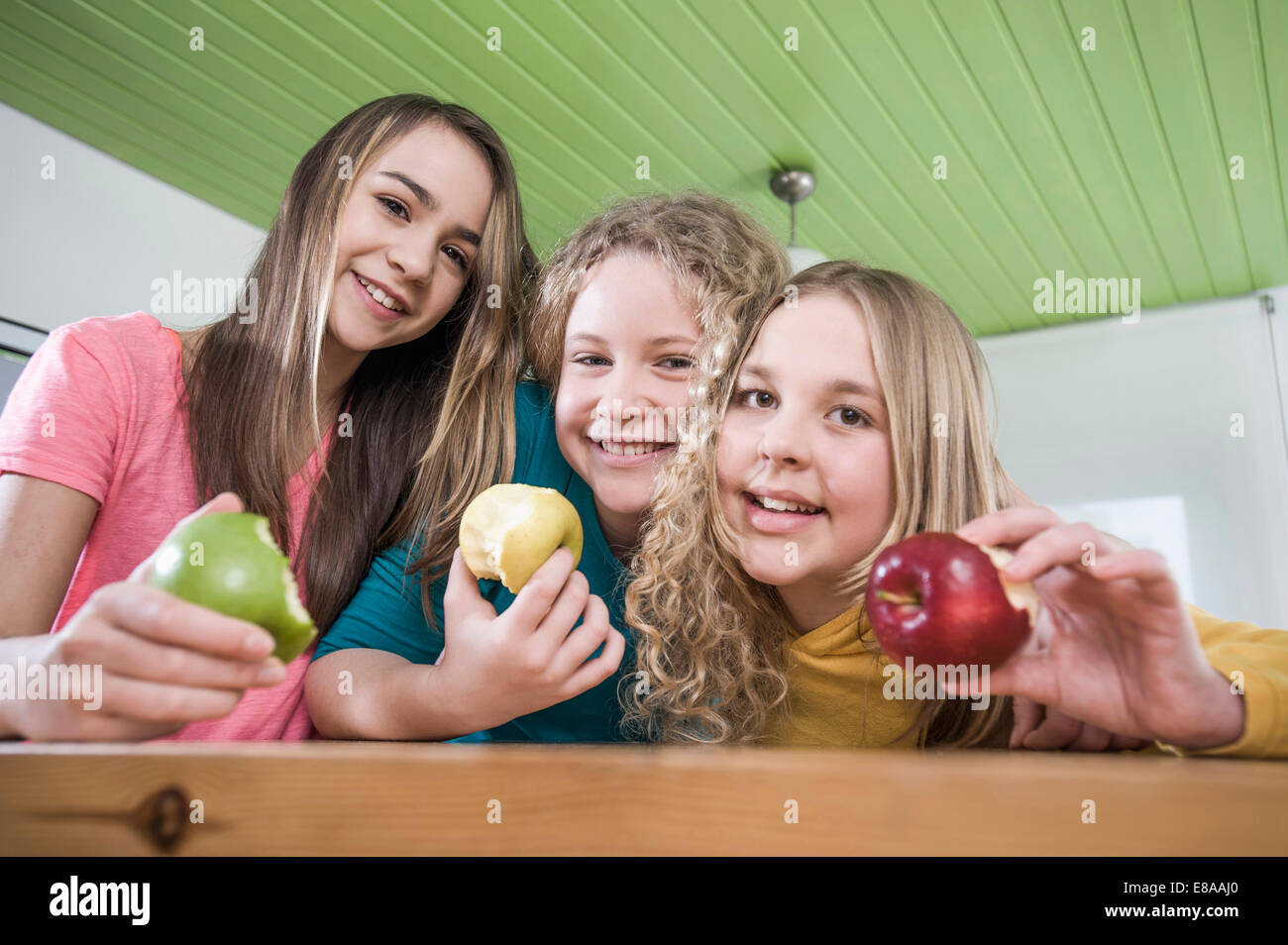 Ragazze in cucina a mangiare le mele Foto Stock