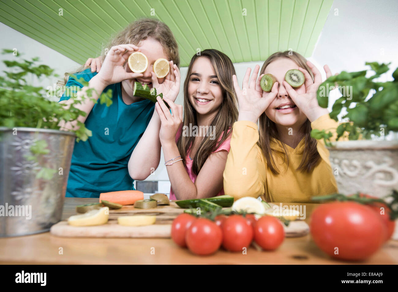 Ragazze in cucina a fare ritratti con frutta Foto Stock