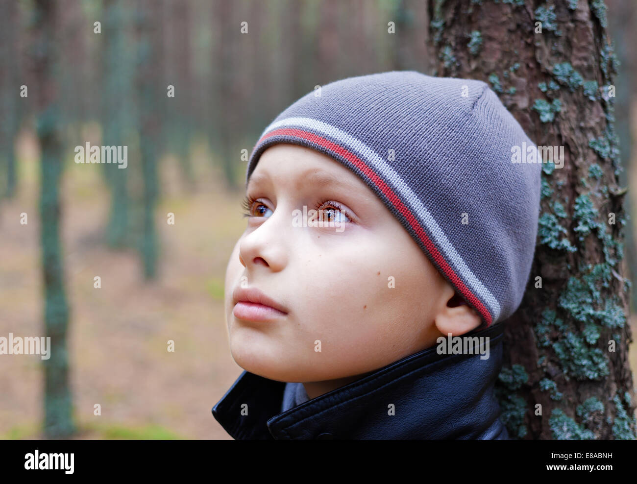 Bambino ragazzo riflessivo pensieroso solo legno di foresta Foto Stock