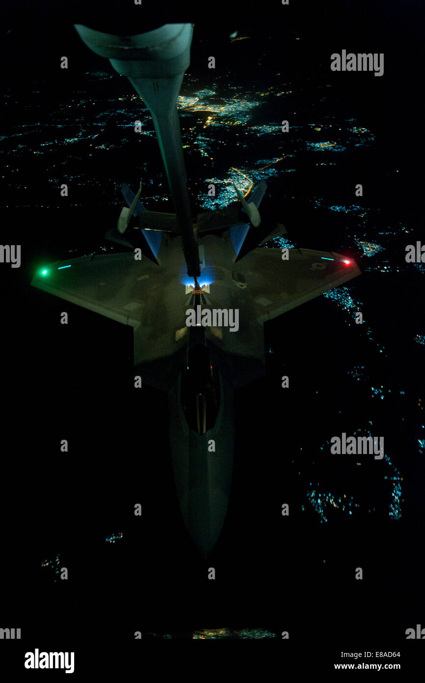 Un U.S. Air Force KC-10 Extender refuels aeromobili un F-22 Raptor aerei sopra una località segreta sett. 26, 2014, prima di colpire le operazioni in Siria. Il presidente Barack Obama ha autorizzato gli aiuti umanitari le consegne in Iraq come pure le incursioni aeree mirate t Foto Stock