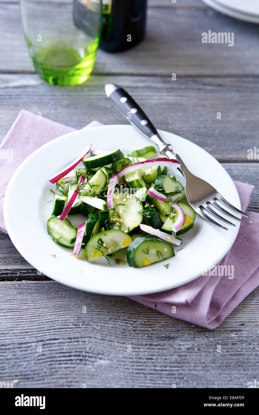 Insalata fresca con il cetriolo su una piastra bianca, vista dall'alto Foto Stock