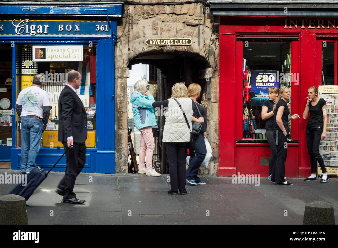 Edinburgh Royal Mile street scene. Tre donne di fumare in strada e i passanti. Foto Stock