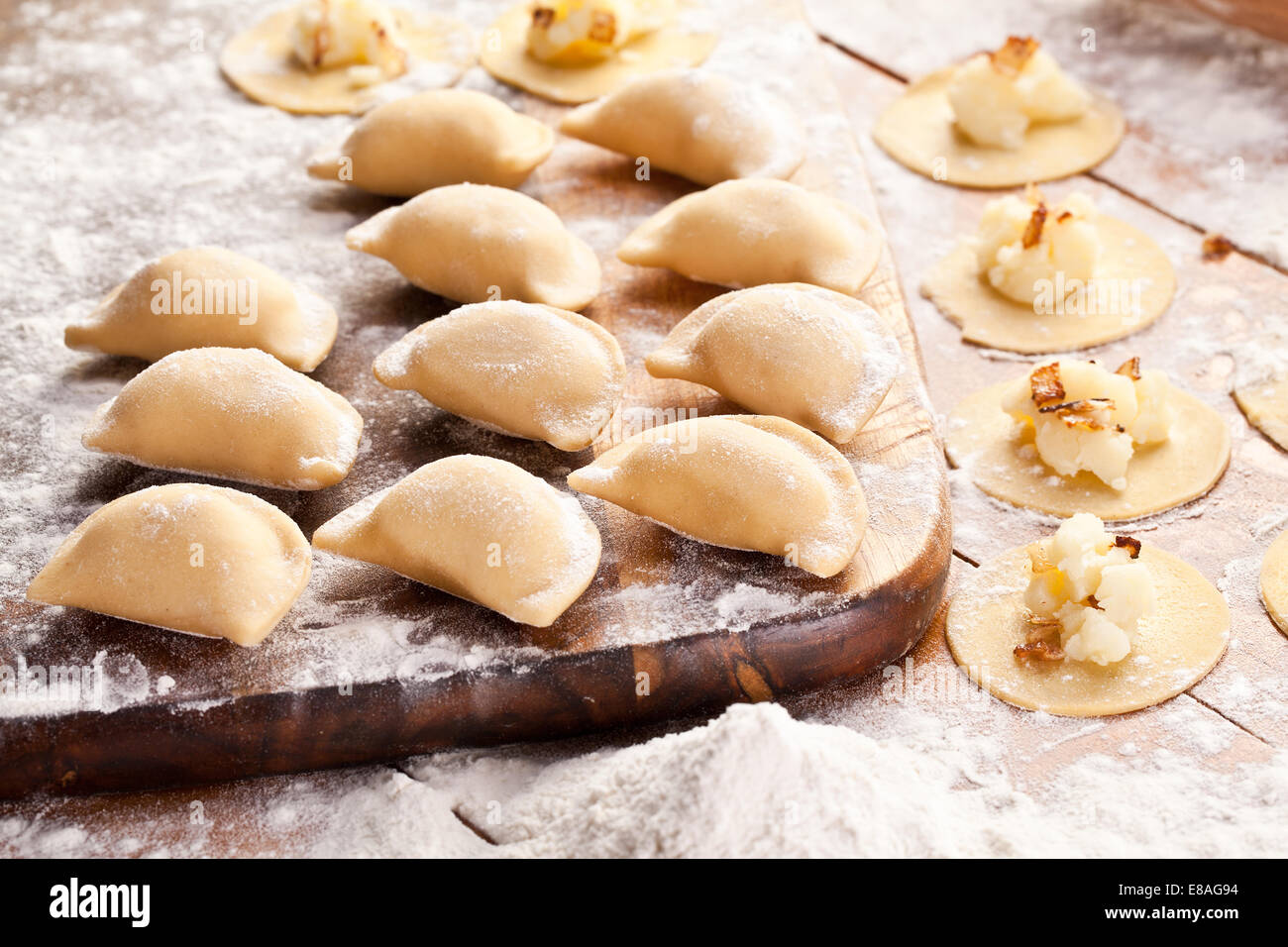 Vareniki canederli con patate e cipolla. Non cotti sulla scrivania in legno. Foto Stock