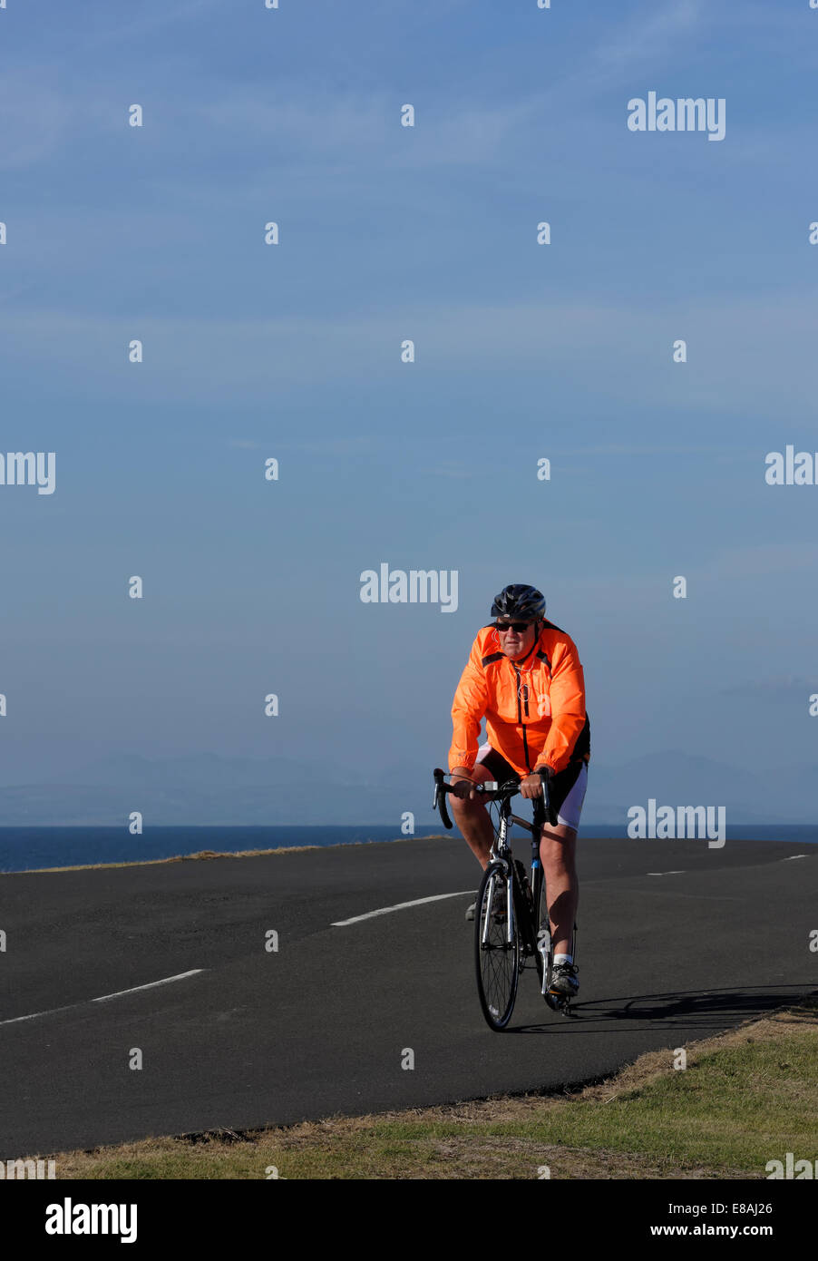 Anziani, maschi ciclista a cavallo, lungo un sentiero costiero di Blackpool, Lancashire, Regno Unito Foto Stock