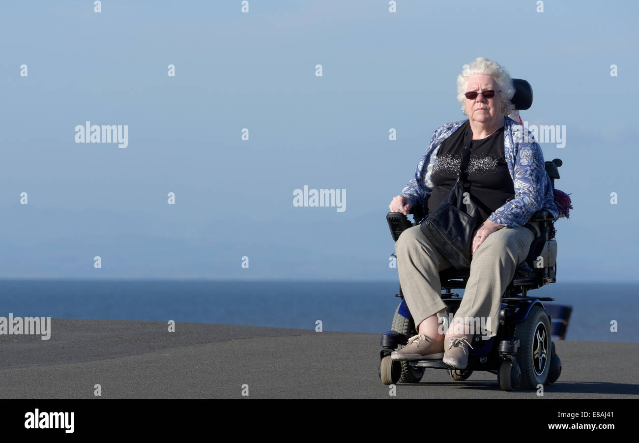 Signora anziana in carrozzina su un sentiero costiero di Blackpool, Lancashire, Regno Unito Foto Stock