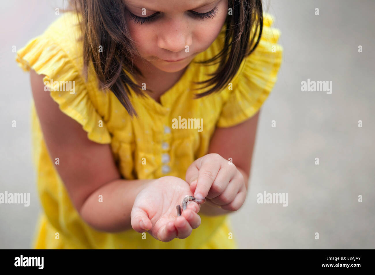 Ragazza holding e guardando in giù a vite senza fine Foto Stock